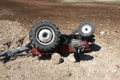 Devrilen traktörün altında sürücü ağır yaralandı